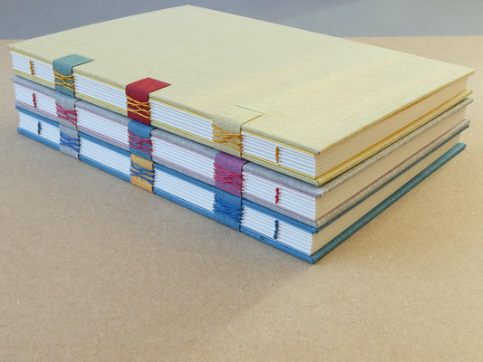 Stack of colourful notebooks on a beige surface