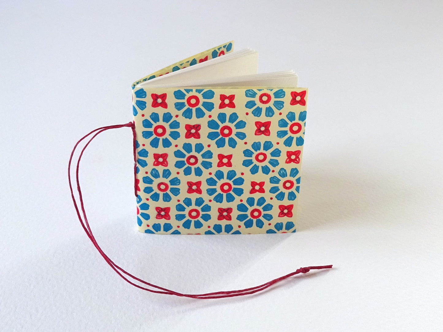 Tiny book for the Christmas tree with Florentine pattern paper and red thread