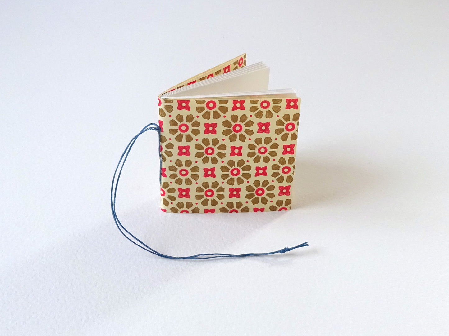 Tiny book for the Christmas tree with Florentine pattern paper and blue thread