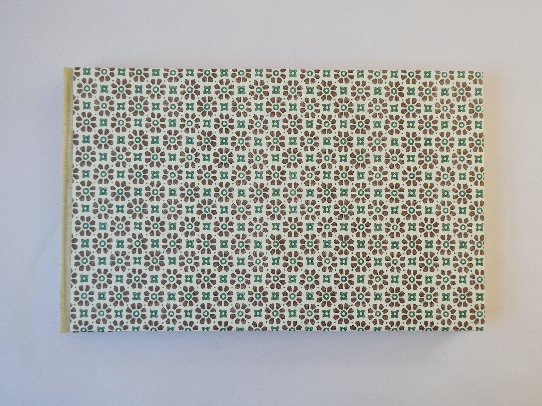 Handmade sketchbook with Italian patterned paper cover on a white surface