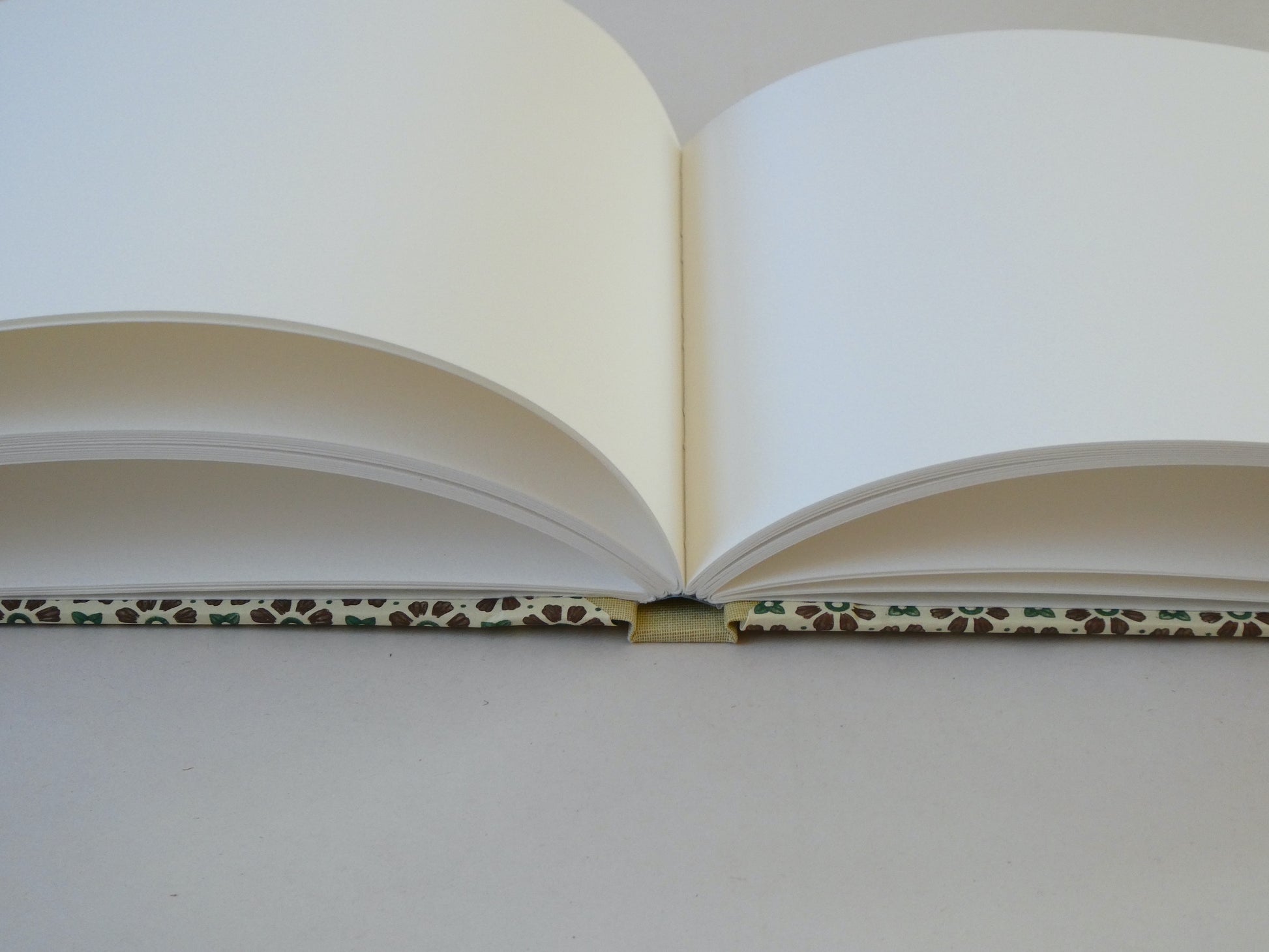 open sketchbook with Italian patterned paper cover on a white surface