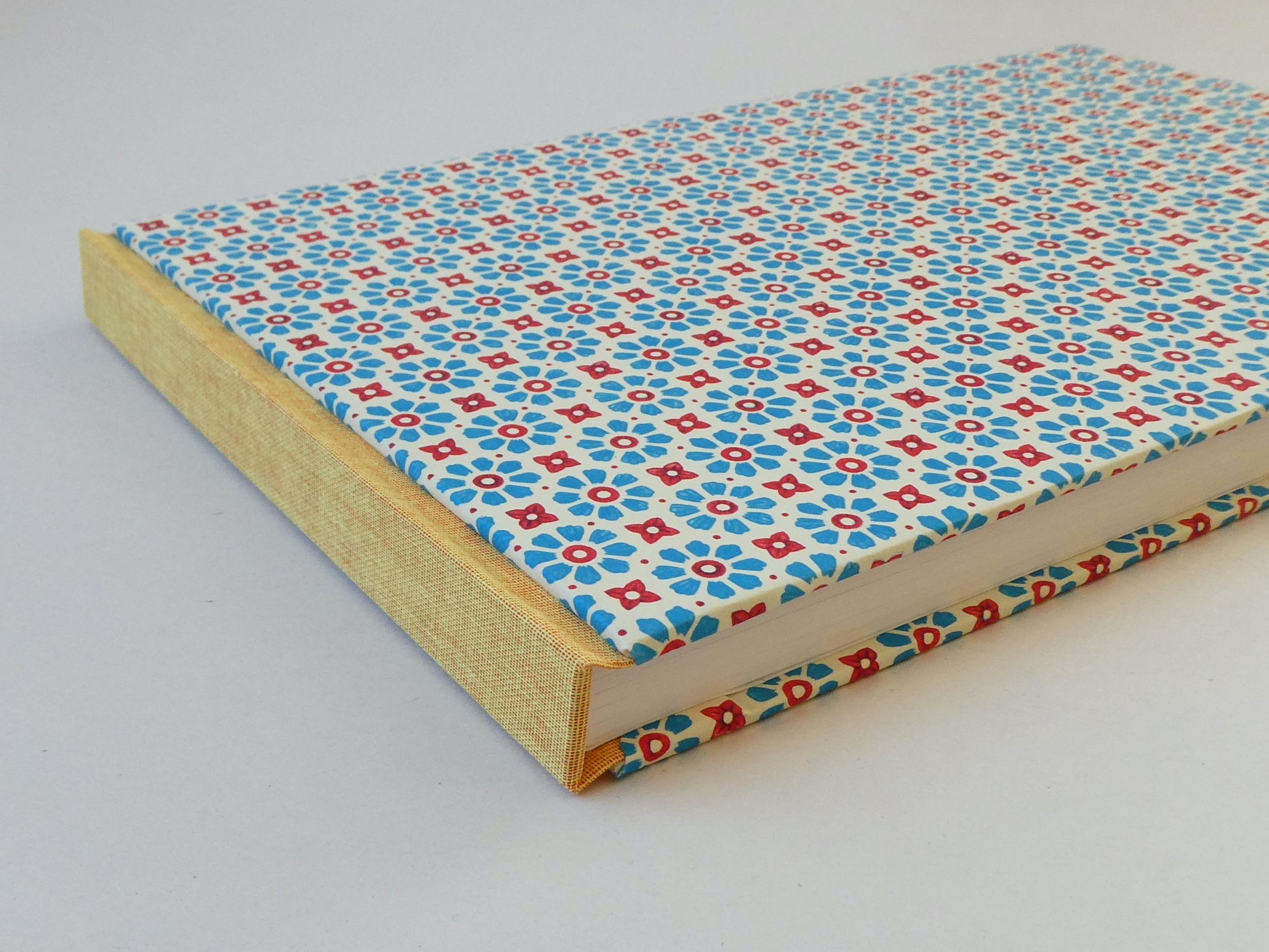 Sketchbook with a blue and red floral pattern on a white background