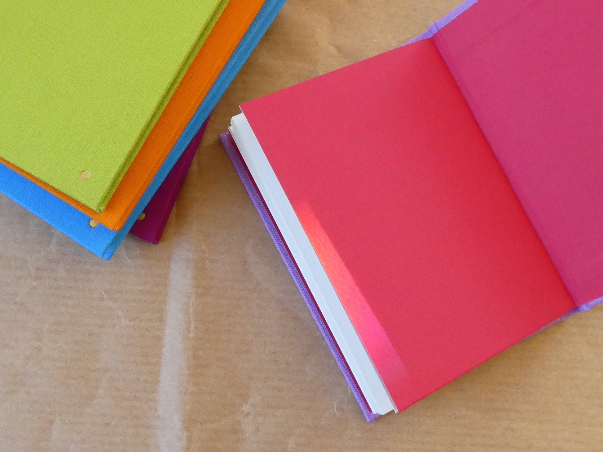 Colourful books stacked on a brown paper surface