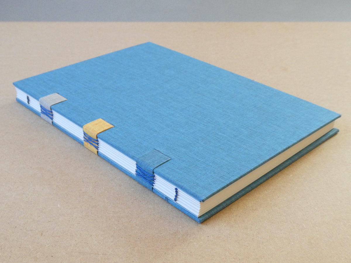 Blue notebook with a textured cover on a beige surface