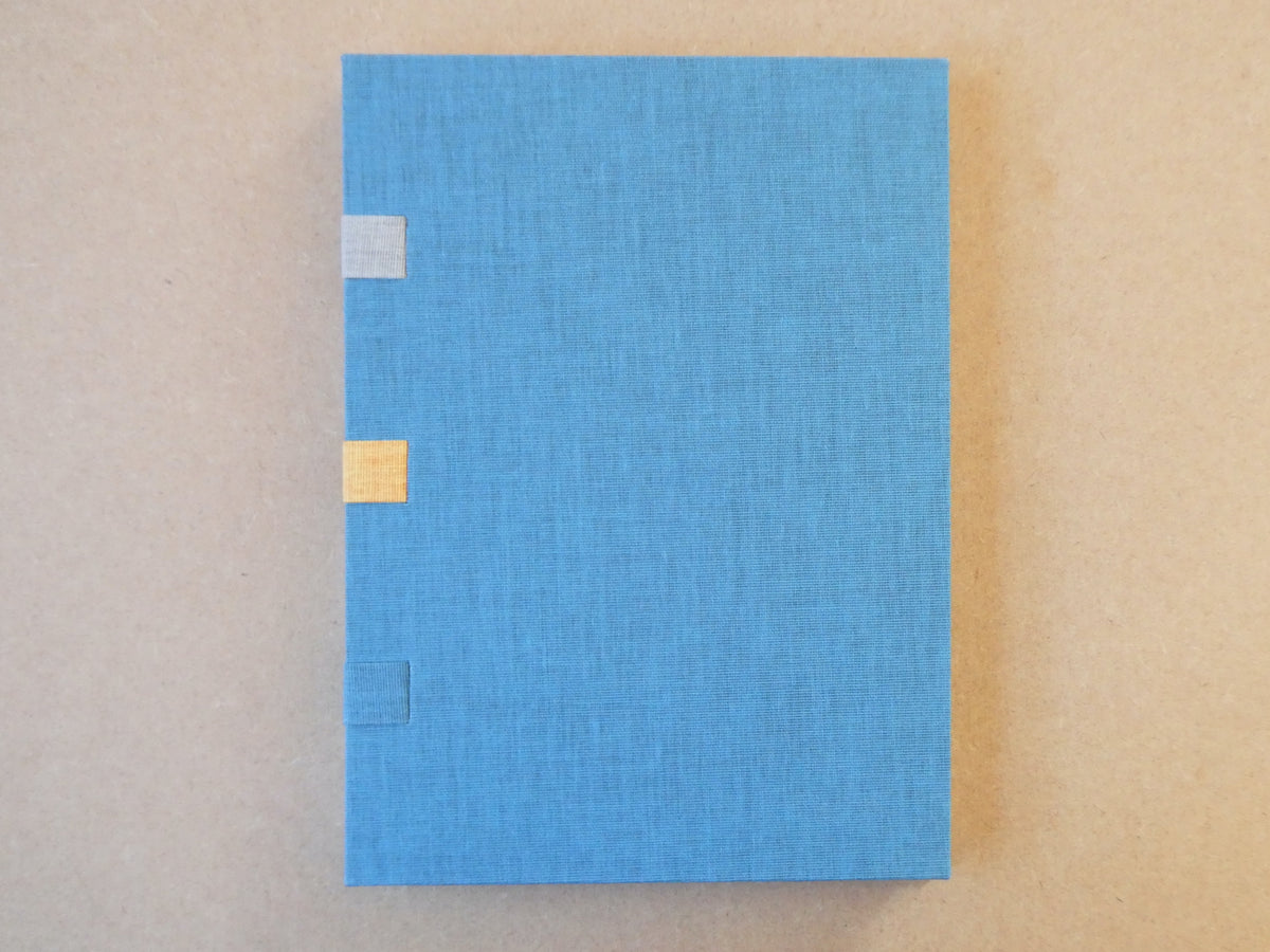 Blue textured box with gold accents on a beige background
