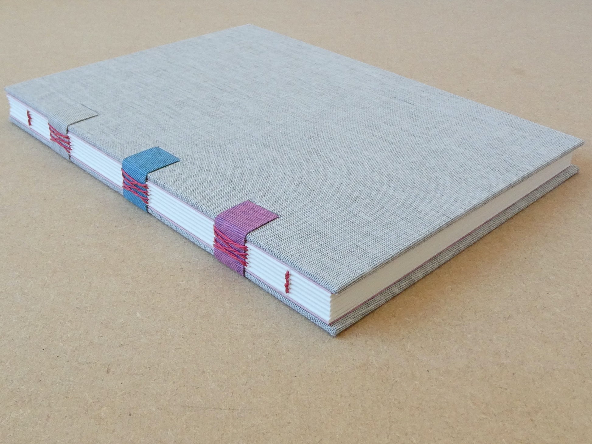 Gray notebook with colorful binding on a beige background