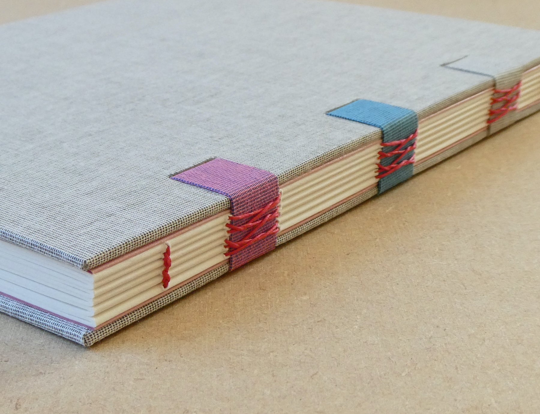 Book with colorful woven spine on a beige surface