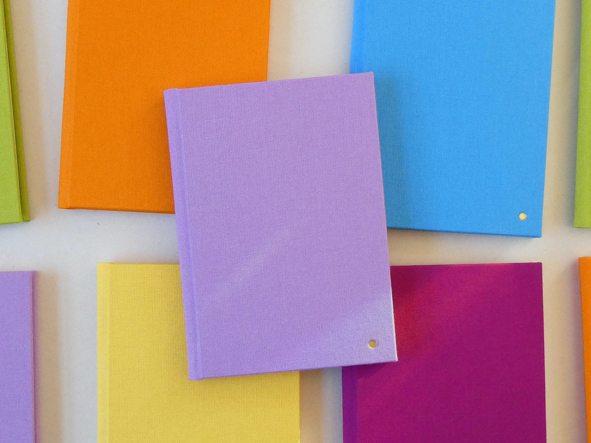 Colourful notebooks arranged on a white background