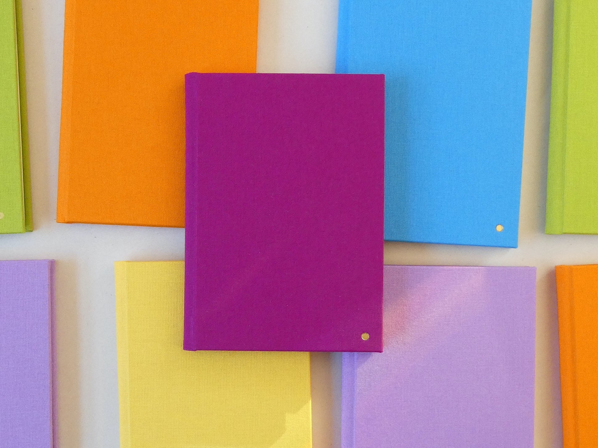 Colourful notebooks arranged in a pattern on a white background