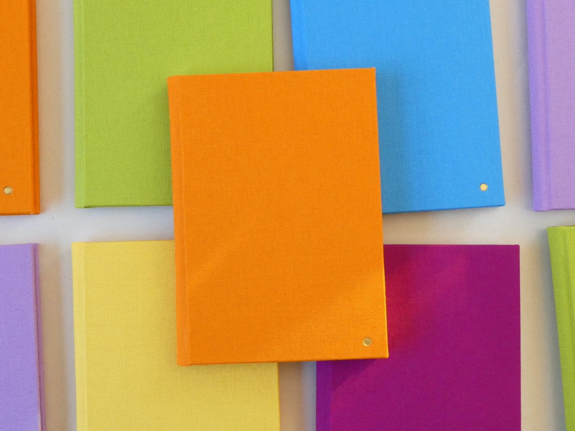 Colourful sketchbooks arranged together on a light background