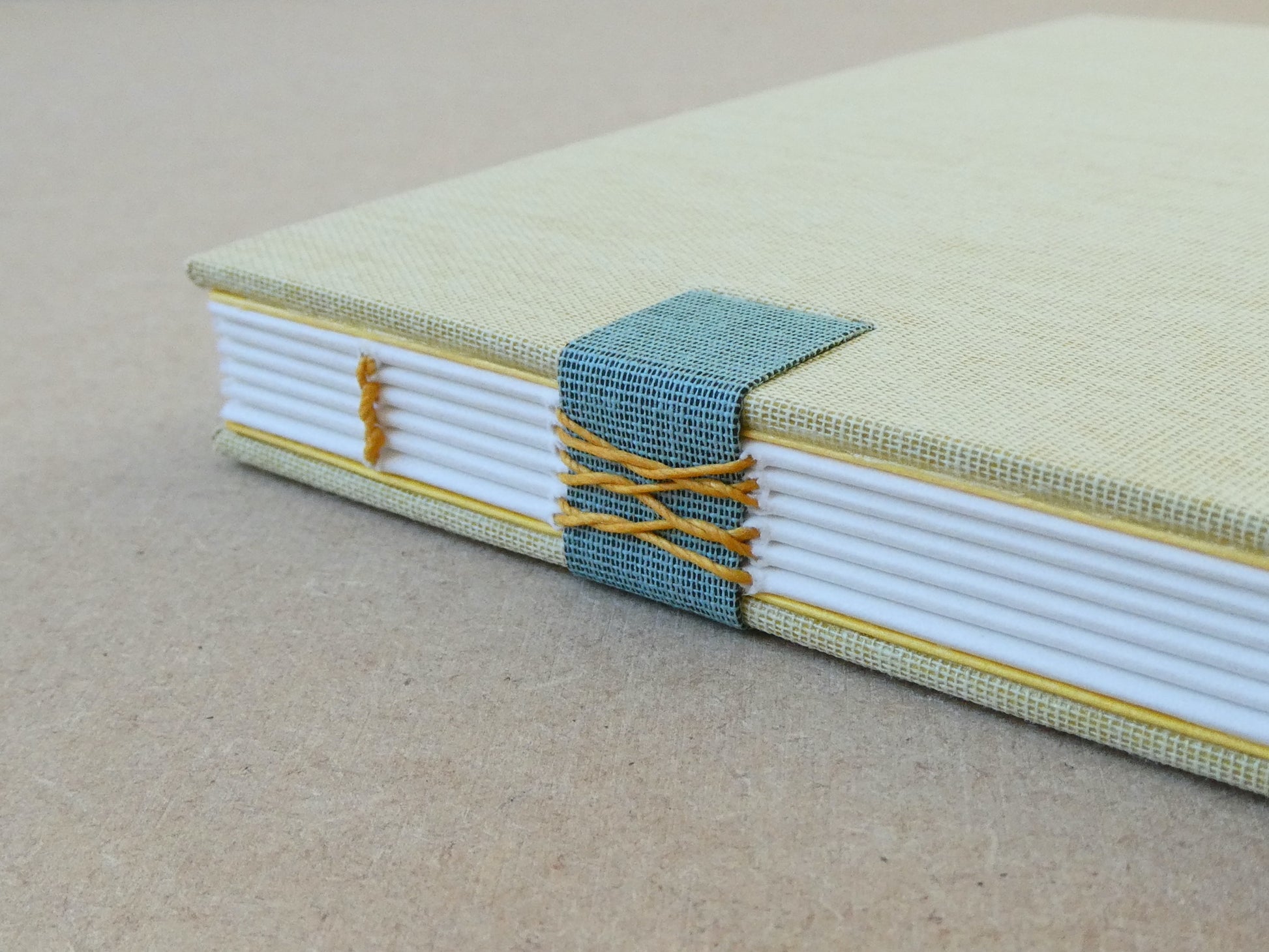 Handmade notebook with a textured cover and white pages on a beige background