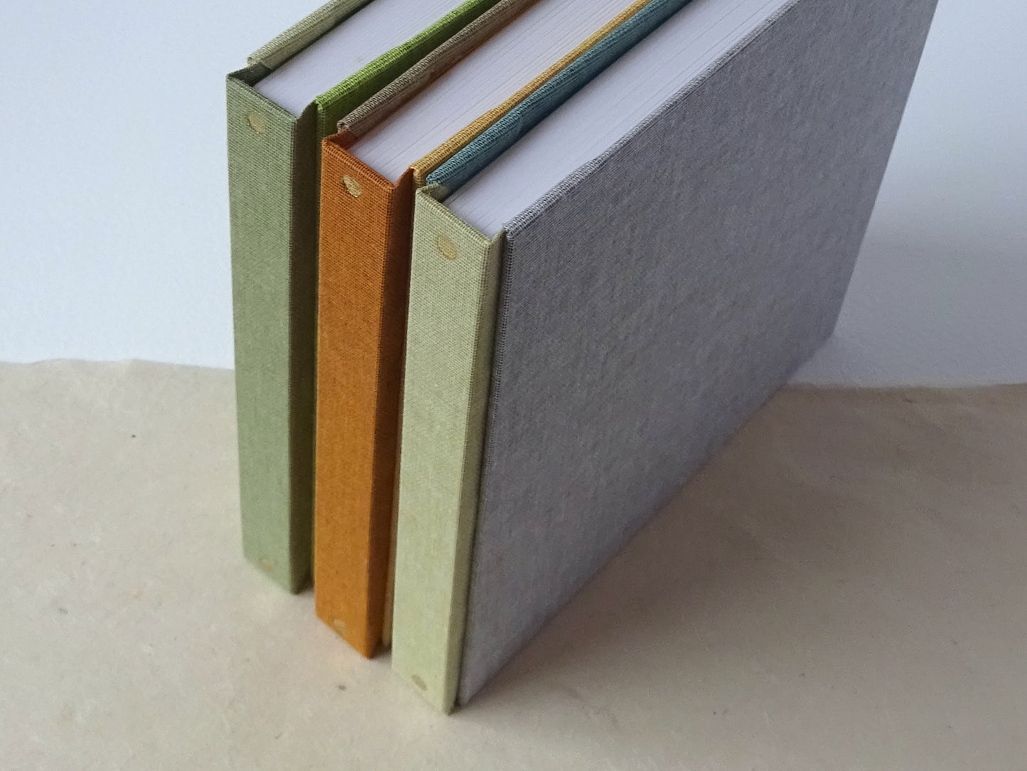 3 three colours square sketchbooks standing