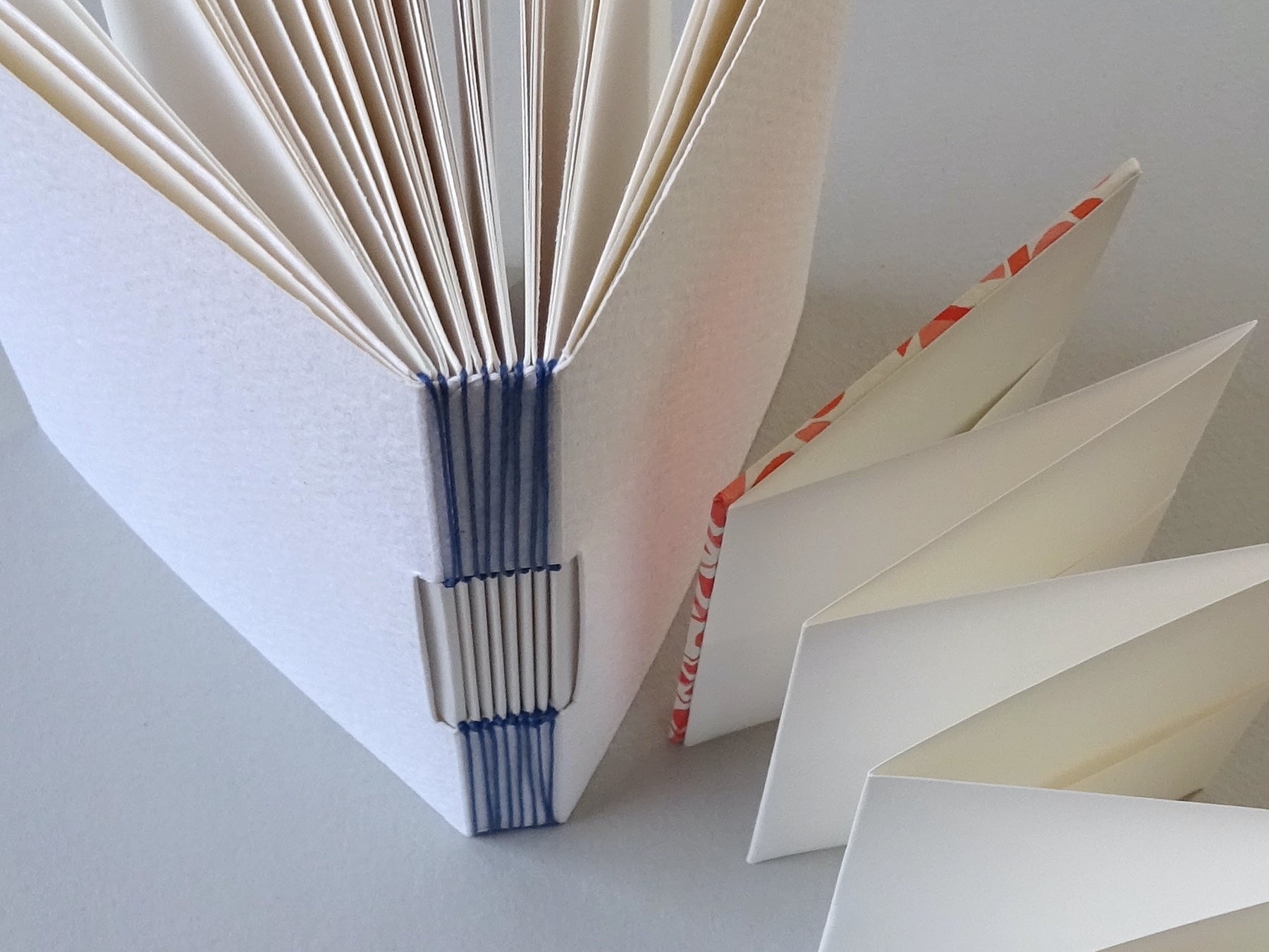 Close-up of a handmade book with open pages on a light gray background