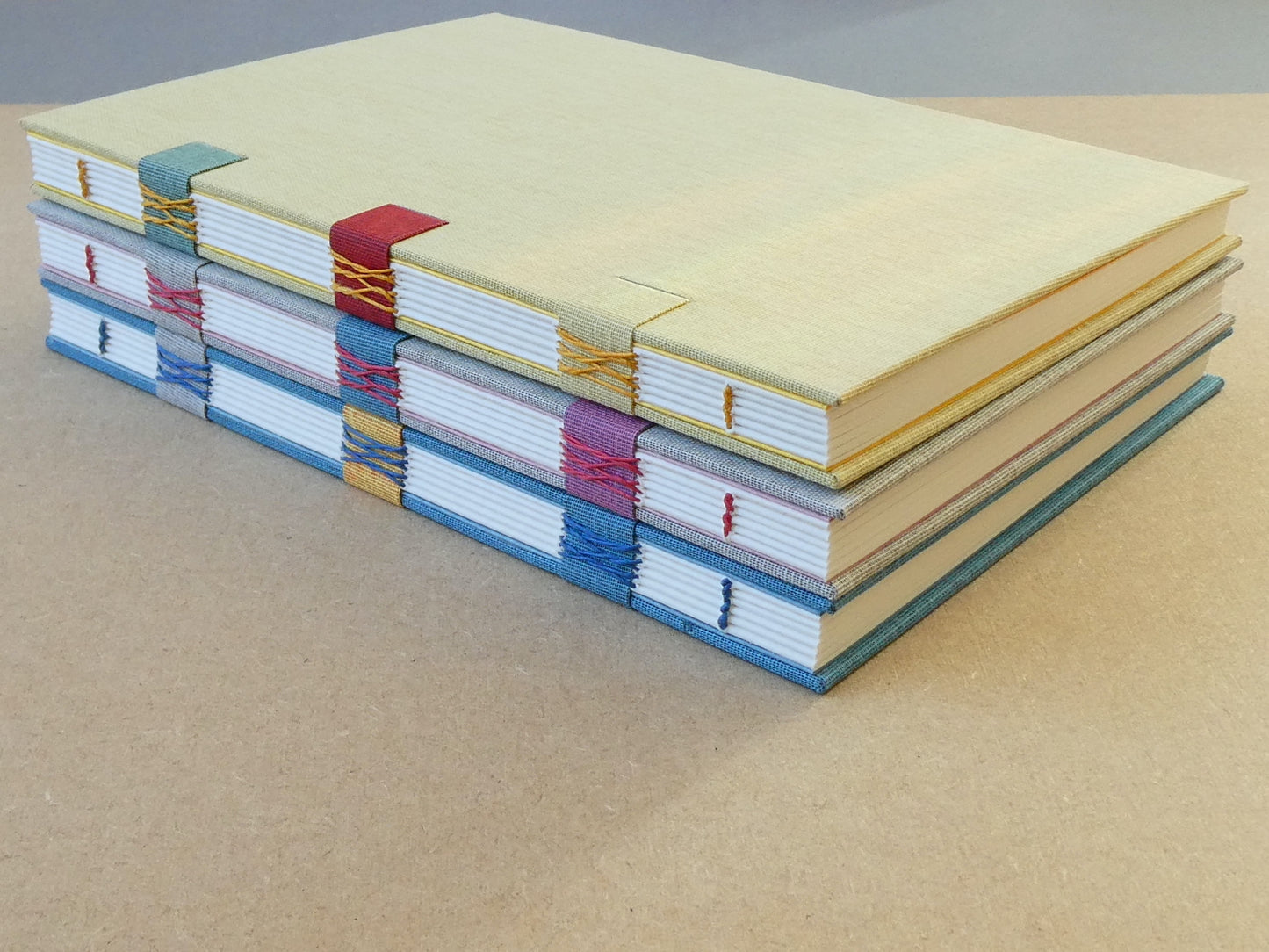 Stack of colourful notebooks on a beige surface