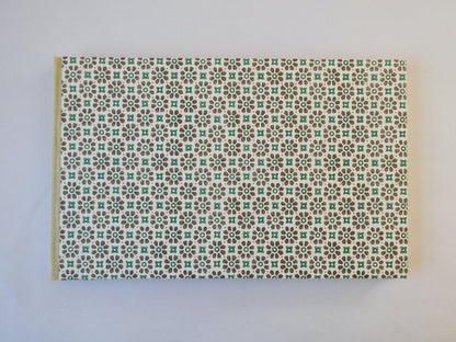 Handmade sketchbook with Italian patterned paper cover on a white surface