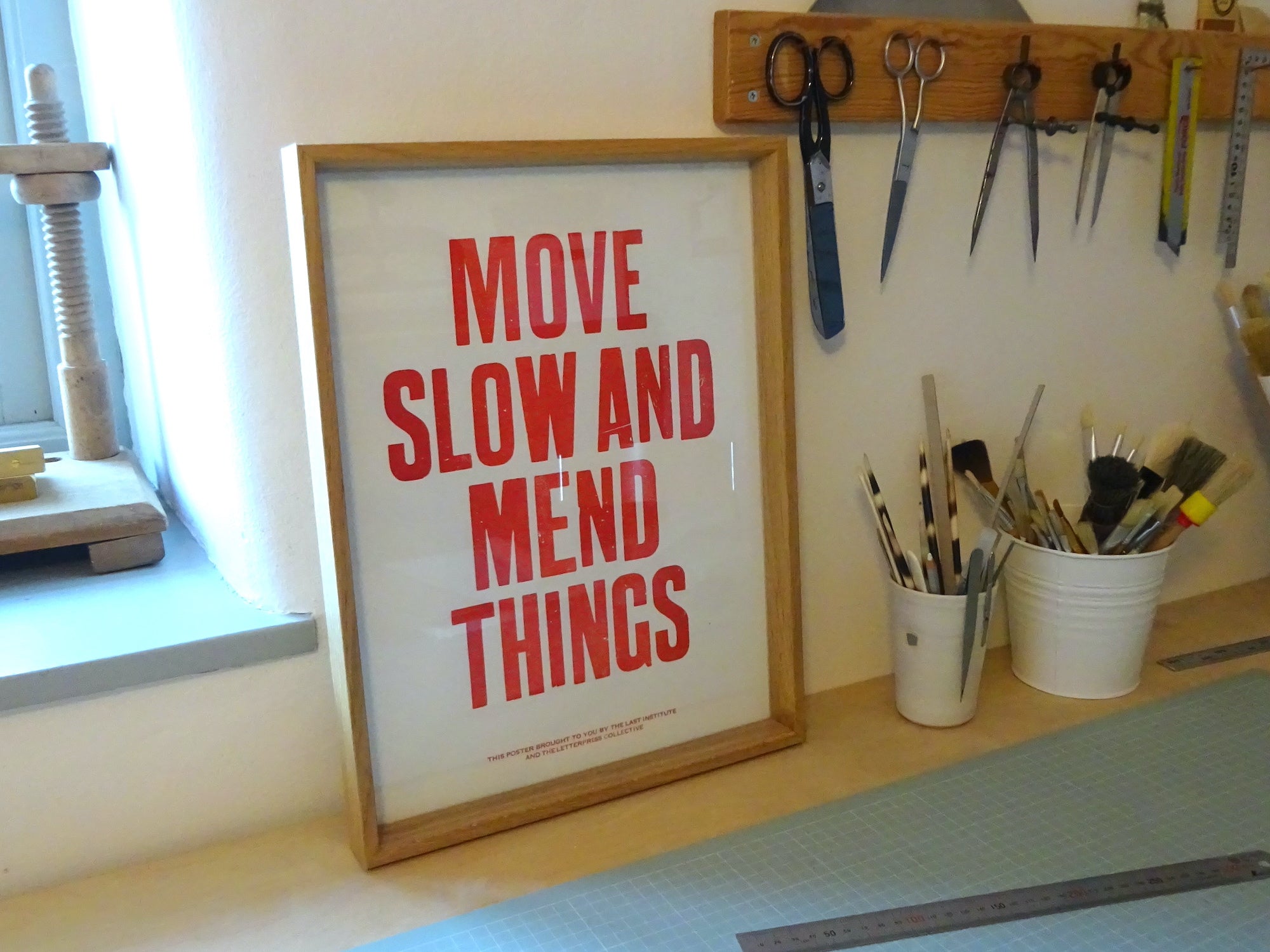 Move slow and mend things letterpress poster in bookbinding studio