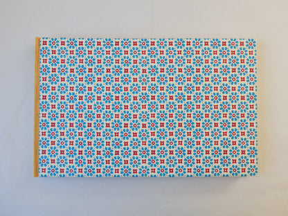 Handmade sketchbook with blue and red Italian patterned paper cover on a white background