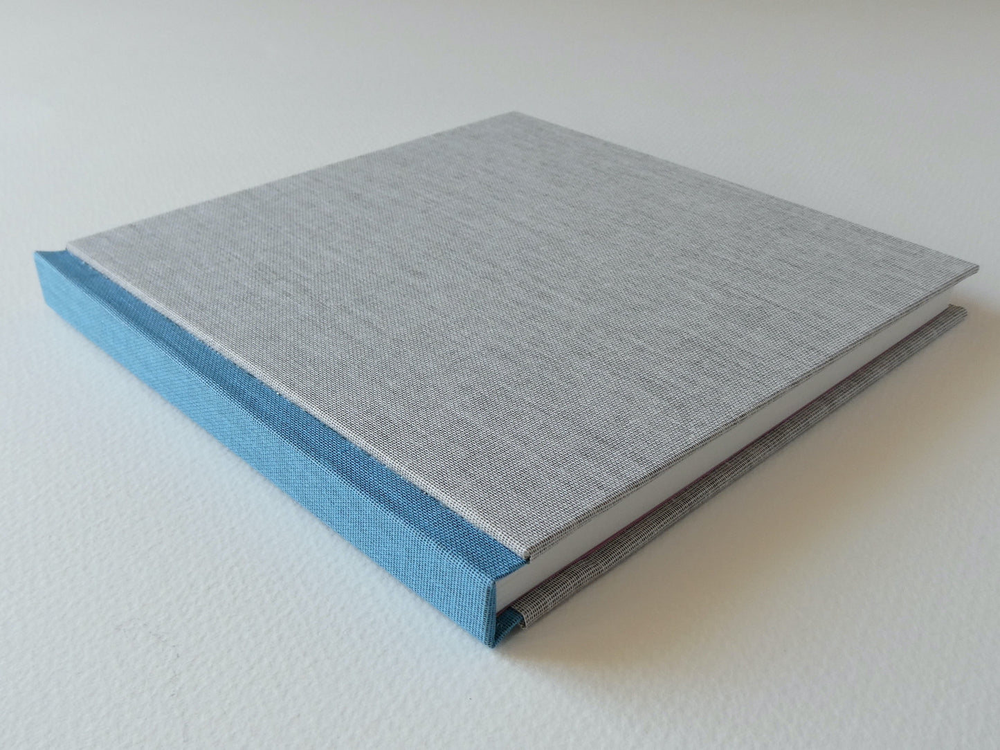 Grey and blue hand bound sketchbook on a white background