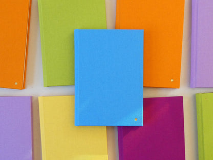 Colourful notebooks arranged in a grid pattern on a light background