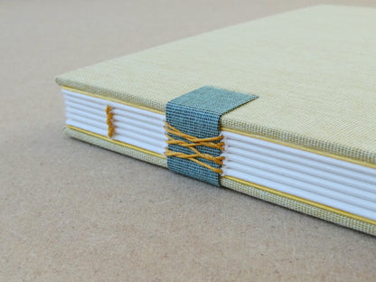 Handmade notebook with a textured cover and white pages on a beige background