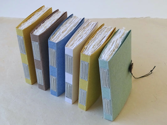 Handmade paper notebooks with vellum plackets and coconut buttons